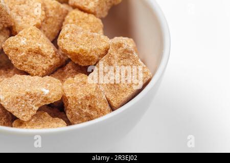 Cubes de sucre de canne brun isolé sur fond blanc Banque D'Images