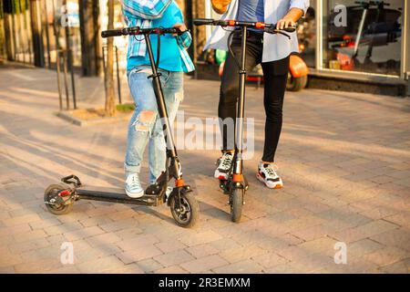 Le couple aimant de conduire un scooter électrique et de regarder l'un l'autre Banque D'Images