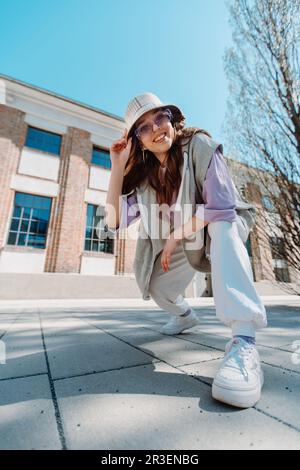 Jeune fille hip hop dans une grande tenue de danse dans un fond urbain minimaliste de musique. Banque D'Images