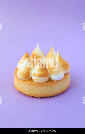 Tartelette au citron sur fond violet. Gros plan de la petite tarte au citron meringue et de la meringue brunie Banque D'Images