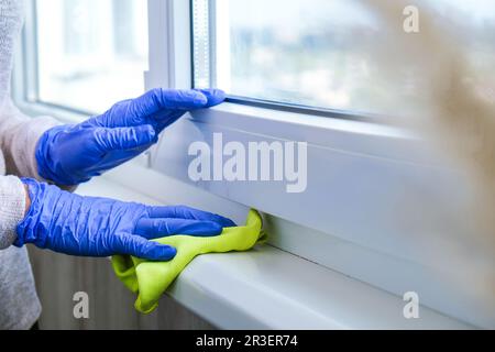 Nettoyage de la poussière d'essuyage du seuil de la vitre à l'aide d'un chiffon en microfibre bleu pour le nettoyage du rail de la vitre gants bleus nettoyage à l'aide d'un SP Banque D'Images