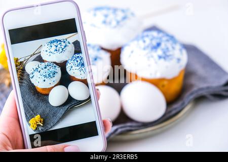 Femme prenant main photo du gâteau de Pâques et des œufs. Joyeuses Pâques. Vacances orthodoxes. Système eas maison tendance et créatif Banque D'Images