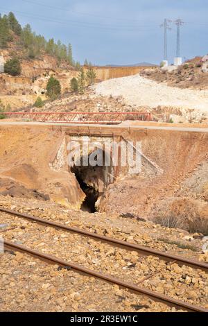 Paysage d'un tunnel dans les mines Rio Tinto avec un pont avec des voies de chemin de fer et des arbres en arrière-plan Banque D'Images