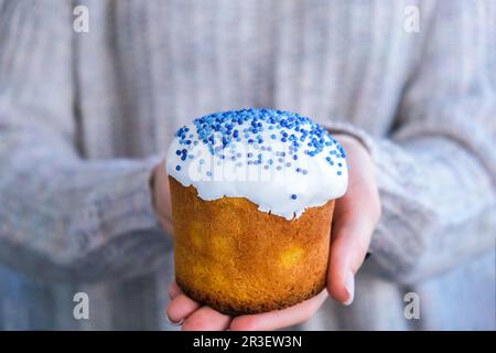 Mains tenir le gâteau de Pâques avec garniture blanche et saupoudrer bleu. Femme tenant un gâteau de Pâques russe traditionnel. Tarte maison pour sp Banque D'Images