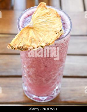 gros plan du dessus d'un smoothie à la fraise garni d'une tranche d'ananas séché Banque D'Images