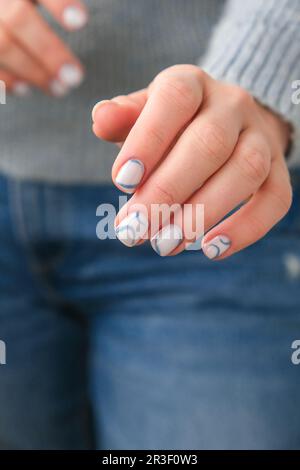 Mains féminines soignées avec des ongles bleus élégants et un design minimaliste. Manucure moderne et tendance. Ongles en gel. Soins de la peau. BEA Banque D'Images