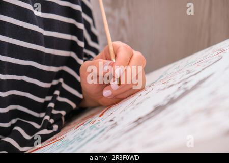 Peinture sur toile par numéros et pots de peinture numérotés. Femme tire avec une brosse. Passe-temps créatif. Peinture pour débutants. Leis Banque D'Images