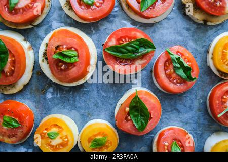 Grosses tomates rouges avec feuilles de basilic vert et fromage mozzarella en préparation pour la cuisson. Des aliments sains faits maison. Cuisson Banque D'Images