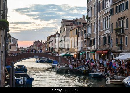 Le pont et le front de mer de la Fondamenta dei Ormesini donnent sur le canal Rio della Misericordia, bondés de touristes lors d'une soirée d'été au coucher du soleil, Venise Banque D'Images