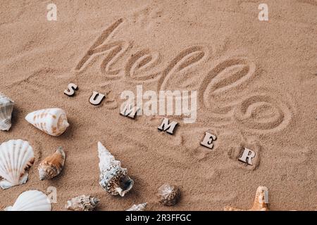 Composition avec texte HELLO ÉTÉ coquillages, galets, maquette sur fond de sable. Vierge, vue de dessus, durée de vie fixe, plat. Somme de mer Banque D'Images