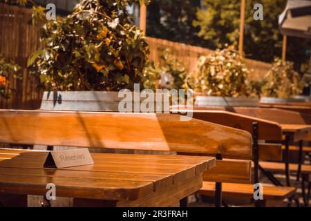 Panneau réservé sur une table en bois dans un café extérieur. Espace pour le texte Banque D'Images