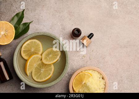 Composition de pose plate avec huile essentielle et citrons sur table texturée grise, espace pour le texte. Traitement d'aromathérapie Banque D'Images