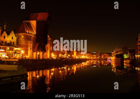 Vieille ville de Gdansk la nuit. Le bord de la rivière Granary Island se reflète dans le paysage urbain de la rivière Moltawa au crépuscule. Grue ancienne à Banque D'Images