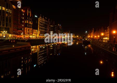 Vieille ville de Gdansk la nuit. Le bord de la rivière Granary Island se reflète dans le paysage urbain de la rivière Moltawa au crépuscule. Grue ancienne à Banque D'Images