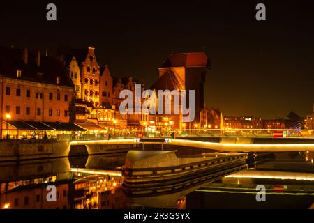 Vieille ville de Gdansk la nuit. Le bord de la rivière Granary Island se reflète dans le paysage urbain de la rivière Moltawa au crépuscule. Grue ancienne à Banque D'Images