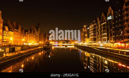 Vieille ville de Gdansk la nuit. Le bord de la rivière Granary Island se reflète dans le paysage urbain de la rivière Moltawa au crépuscule. Grue ancienne à Banque D'Images