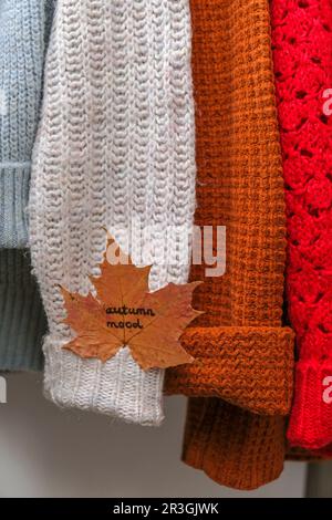 Concept d'automne. Feuille d'érable d'automne avec texte D'AMBIANCE AUTOMNALE sur un pull chaud et confortable. Pulls tricotés en laine et mohair. Style hygge Banque D'Images