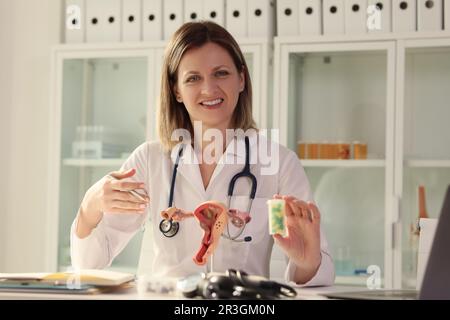 Lady gynécologue tient une bouteille de pilules regardant dans l'appareil photo Banque D'Images