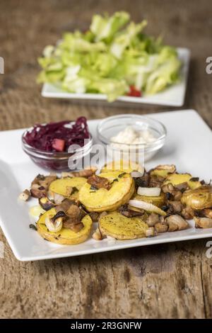 Gröstl bavarois avec salade sur bois Banque D'Images