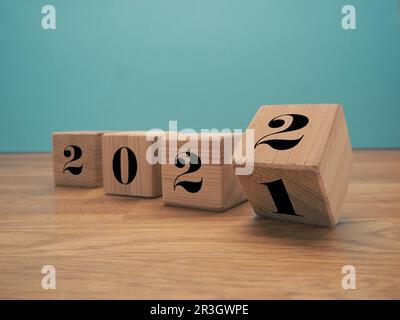 Des cubes en bois à retourner avec les numéros de l'année 2021 et 2022, concept du nouvel an, période de Noël saisonnière Banque D'Images