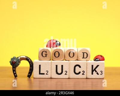 Bonne chance sur les blocs de bois et la décoration sur un fond jaune, le concept du nouvel an ou de l'anniversaire Banque D'Images