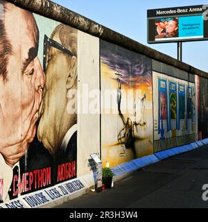 Bruderkuss, Gemaelde von Dmitri Vrubel auf einem Rest der Berliner Mauer mit Werbung fuer Tabakgenuss, East Side Gallery, Berlin, Deutschland, Europa Banque D'Images