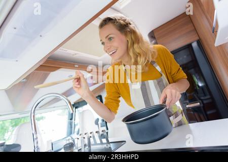 femme cuisinant dans camping-car Banque D'Images