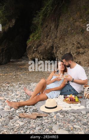 Un jeune couple heureux pique-nique sur la plage Banque D'Images