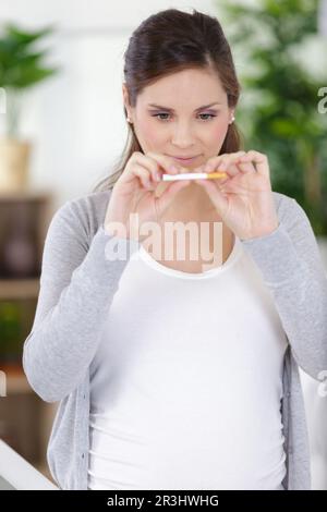 femme enceinte cassant une cigarette Banque D'Images