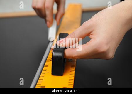 Femme dessin avec craie et règle triangulaire sur tableau noir, gros plan Banque D'Images