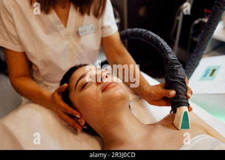 Procédé de l'appareil de massage du drainage lymphatique GPL. L'esthéticienne thérapeute fait un massage du visage rajeunissant pour le modèle dans un salon de beauté. Gros plan, Banque D'Images