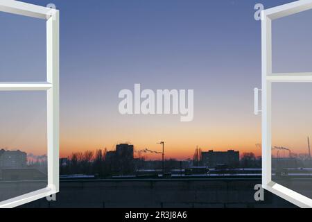 Fenêtre panoramique avec vue sur le coucher de soleil rouge au-dessus des bâtiments de la ville. Paysage urbain en soirée. Vue magnifique Banque D'Images