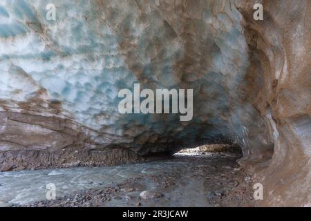 Grotte impressionnante sculptée dans la glace du glacier de Vallelunga traversée par un ruisseau, en Italie Banque D'Images