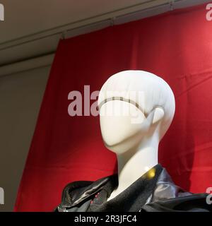 Tête d'une mannequin féminine sur fond rouge dans une vitrine à Colmar en France Banque D'Images