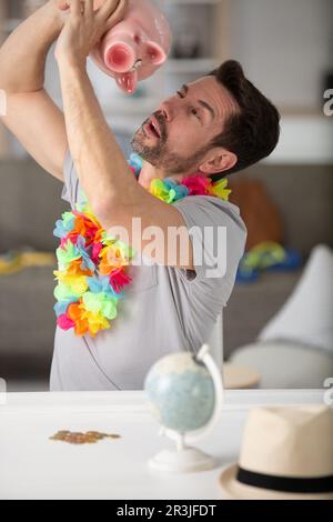 homme tenant une banque de pigey essayant de sortir de l'argent Banque D'Images