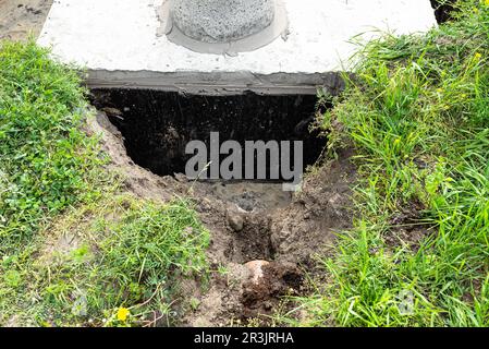 Fosse septique en béton d'une capacité de 10 mètres cubes placée dans le jardin près de la maison, eau visible en dessous. Banque D'Images