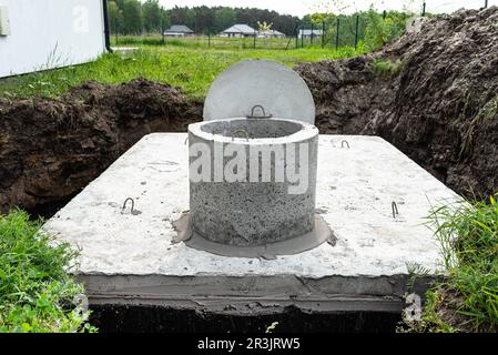 Fosse septique en béton d'une capacité de 10 mètres cubes placée dans le jardin près de la maison, eau visible en dessous. Banque D'Images