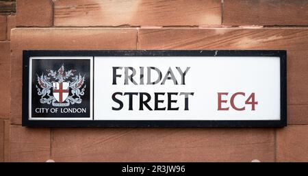 Un panneau rectangulaire indiquant le nom de la rue Friday Street dans la ville de Londres, au Royaume-Uni. Avec l'emblématique cimier de la ville de Londres et le code postal EC4, ce symbole historique Banque D'Images