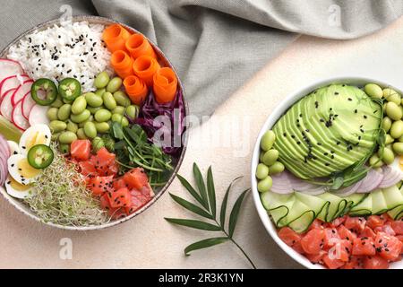 Délicieux poke bols avec des légumes, du poisson et des haricots édamames sur une table légère, plat Banque D'Images