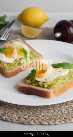 Délicieux sandwichs avec œufs durs, avocat et épinards sur la table Banque D'Images