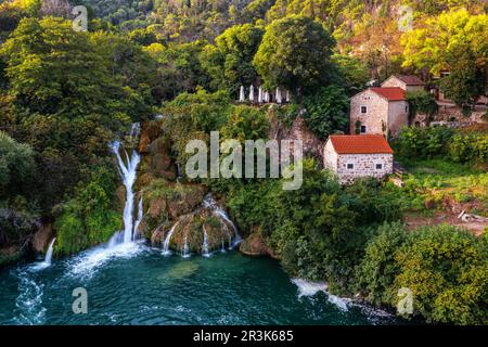 Krka, Croatie - vue aérienne des magnifiques cascades de Krka dans le parc national de Krka, le matin d'été avec des petites maisons traditionnelles Banque D'Images