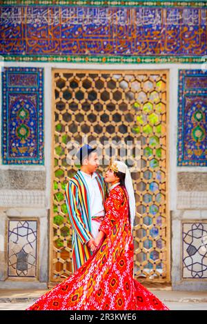 Samarkand, Ouzbékistan - 18 avril 2021 : mariée et marié dans des robes ouzbèkes traditionnelles à la ville antique du Registan, Samarkand ville en Ouzbékistan Banque D'Images