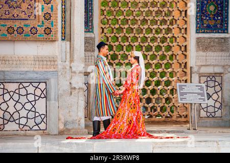 Samarkand, Ouzbékistan - 18 avril 2021 : mariée et marié dans des robes ouzbèkes traditionnelles à la ville antique du Registan, Samarkand ville en Ouzbékistan Banque D'Images