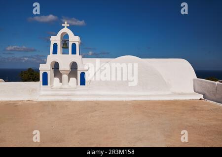 Petite église blanche dans une terrasse avec sa tour Bells dans le village d'Oia - île de Santorini, Grèce - carte postale vue Banque D'Images