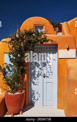 Belle vue depuis le village d'Oia avec maison traditionnelle orange et porte en bois sur l'île de Santorini en mer Egée, Grèce Banque D'Images