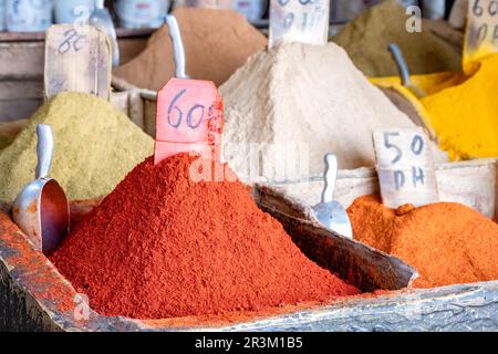 Des épices en vrac en vente sur le marché aux épices, la Mellah dans le quartier juif de Marrakech. Les épices sont en piles colorées et sont indiquées avec des étiquettes de prix Banque D'Images