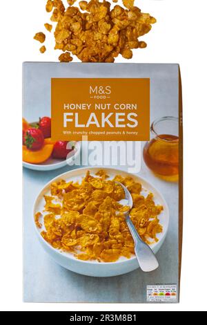 Boîte de cornflakes aux noix de miel avec arachides croquantes hachées et céréales au miel de M&S ouverte avec contenu renversé isolé sur fond blanc Banque D'Images