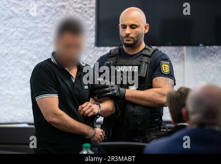 Stuttgart, Allemagne. 24th mai 2023. Un homme accusé est conduit par un fonctionnaire du tribunal dans une salle du tribunal régional de Stuttgart. Le défendeur de 36 ans est accusé de tuer une fille de 17 ans en juillet 2022. Credit: Christoph Schmidt/dpa/Alay Live News Banque D'Images