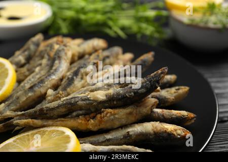 Assiette avec de délicieux anchois frits et des tranches de citron, gros plan Banque D'Images