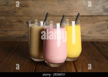 Verres avec différents smoothies sur une table en bois Banque D'Images